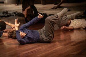 roup of people dancing and improvising in a room with a wooden floor