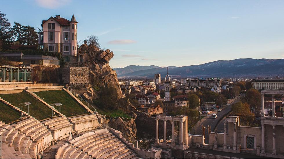 A panoramic view of the city of Plovdiv, Bulgaria, with ancient buildings, and mountains in the background