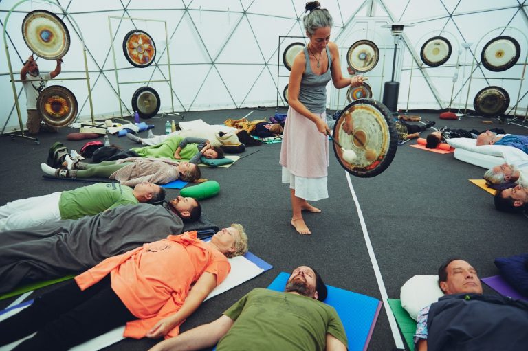 Gong Bath session with people lying on a circle on the ground