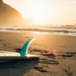 A surfing board on a sandy beach